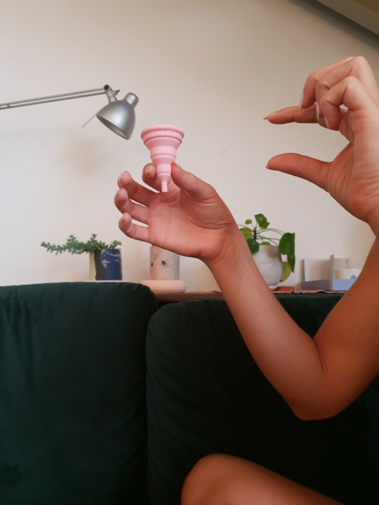 sofa background with a women and a pink period cupLily Compact is a one of the best menstrual cups or periods cups that we have! It's light pink and compact! כוס מחזור או גביעונית מדהימה שתעזור לך לאסוף את המחזור שלך!תעשי משהו טוב בשביל עצמך