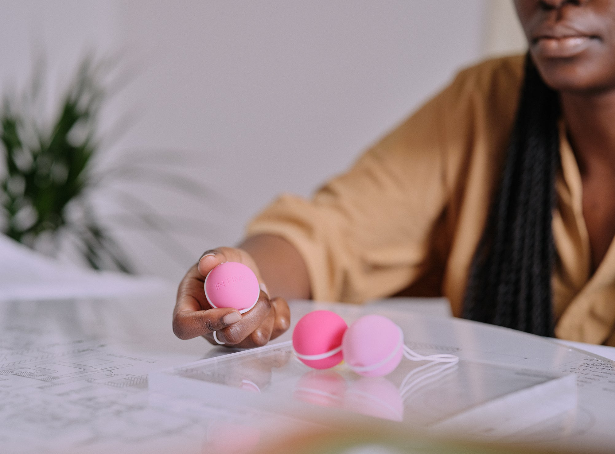 3 kegel weights in pink held by a women wearing orange. Enjoy a strong pelvic floor . מוצרי המחזור הרב פעמים הכי טובים ונוחים בישראל, תחזקי את רצפת האגן שלך עם אהבה