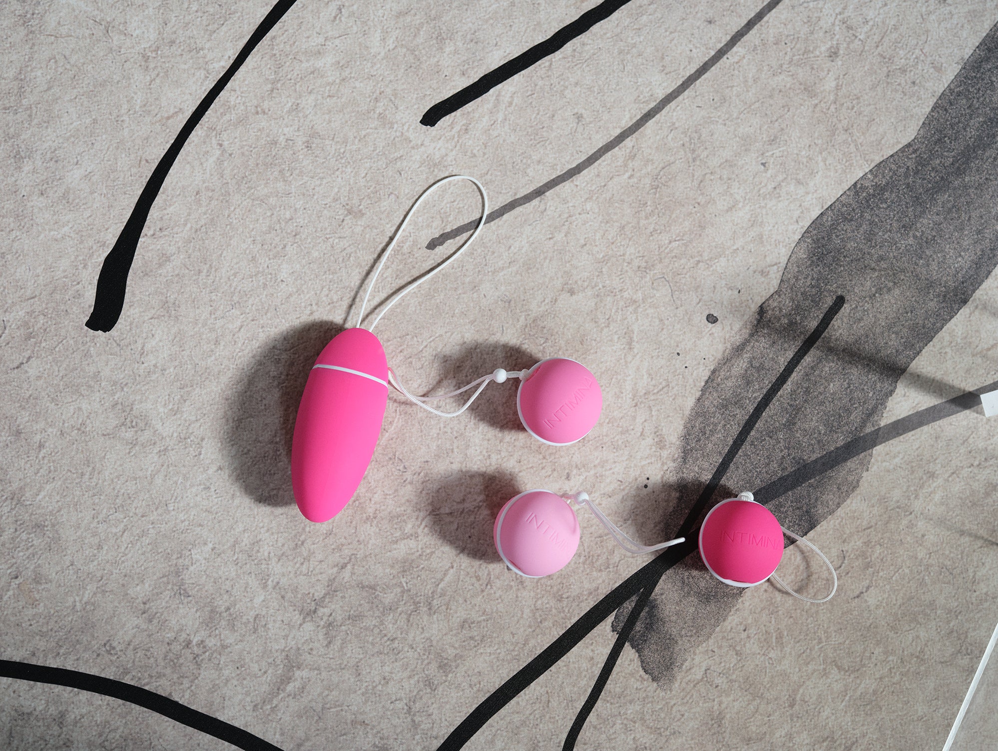 4 kegel weights in pink on a concrete background. Enjoy a strong pelvic floor . מוצרי המחזור הרב פעמים הכי טובים ונוחים בישראל, תחזקי את רצפת האגן שלך עם אהבה