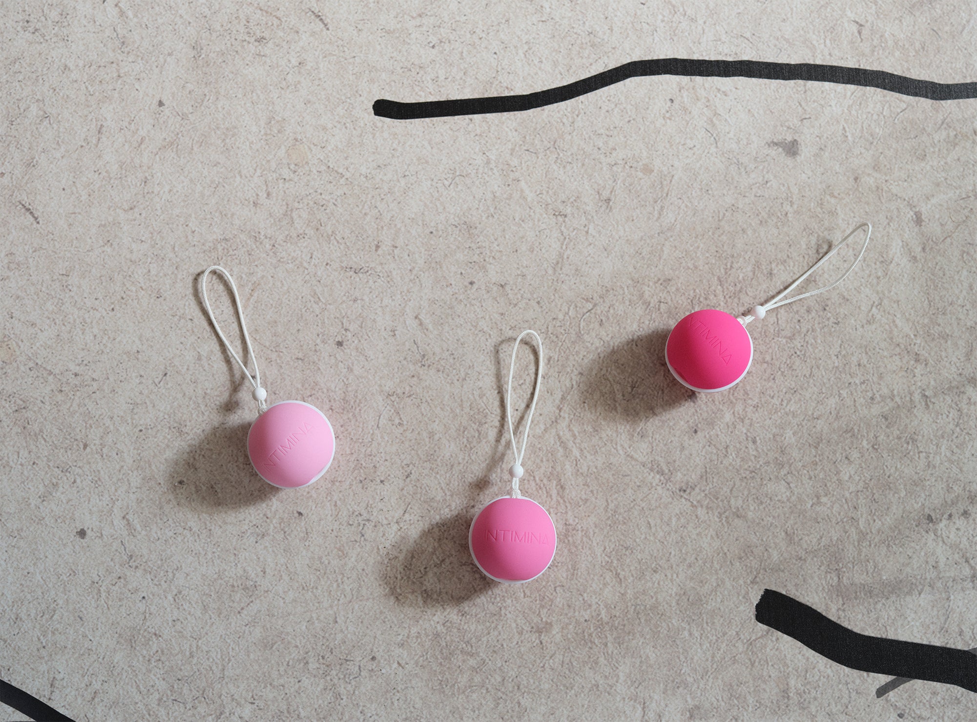 3 kegel weights in pink on a concrete background. Enjoy a strong pelvic floor . מוצרי המחזור הרב פעמים הכי טובים ונוחים בישראל, תחזקי את רצפת האגן שלך עם אהבה