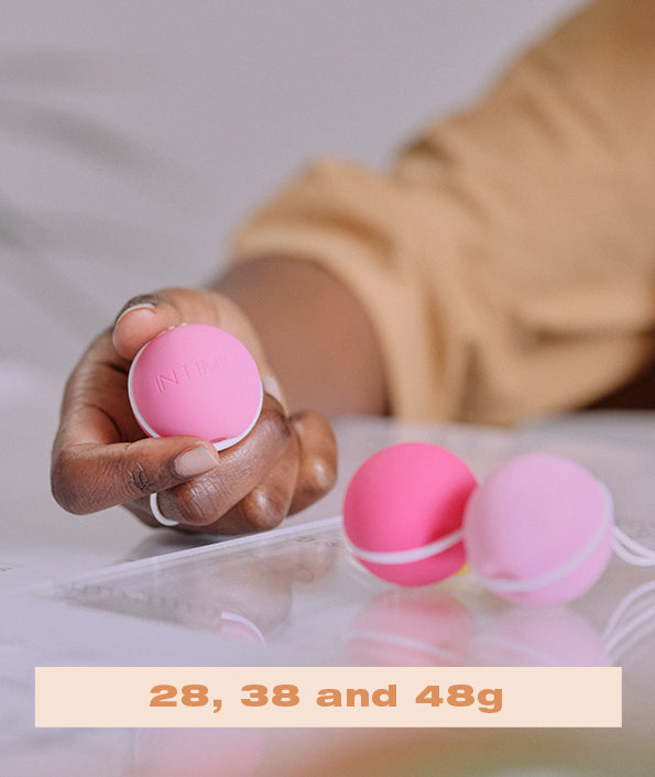 3 kegel weights in pink  held by a womne wearing orange.Enjoy a strong pelvic floor . מוצרי המחזור הרב פעמים הכי טובים ונוחים בישראל, תחזקי את רצפת האגן שלך עם אהבה