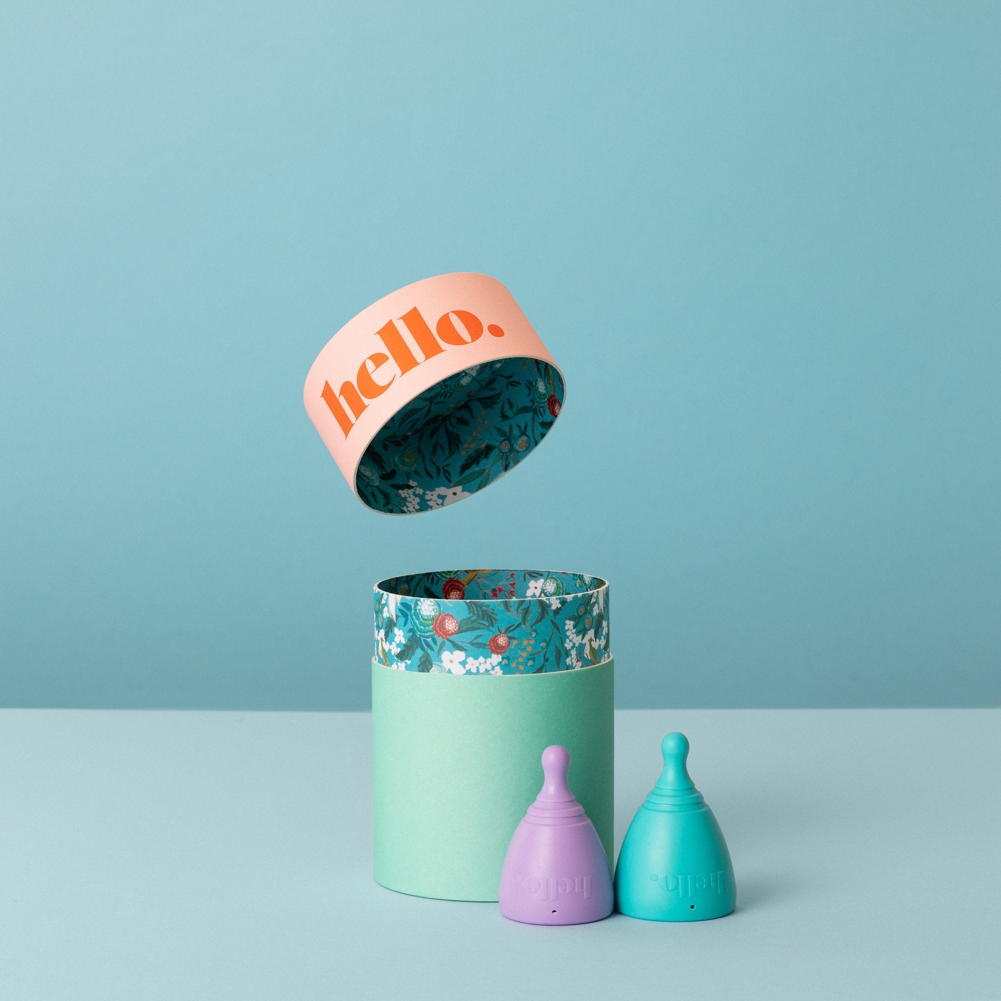 hello low lilac blue menstrual cup in beside box orange background. הגביעונית הרב פעמית לווסת בארץ לנשים עם צוואר רחם נמוך
