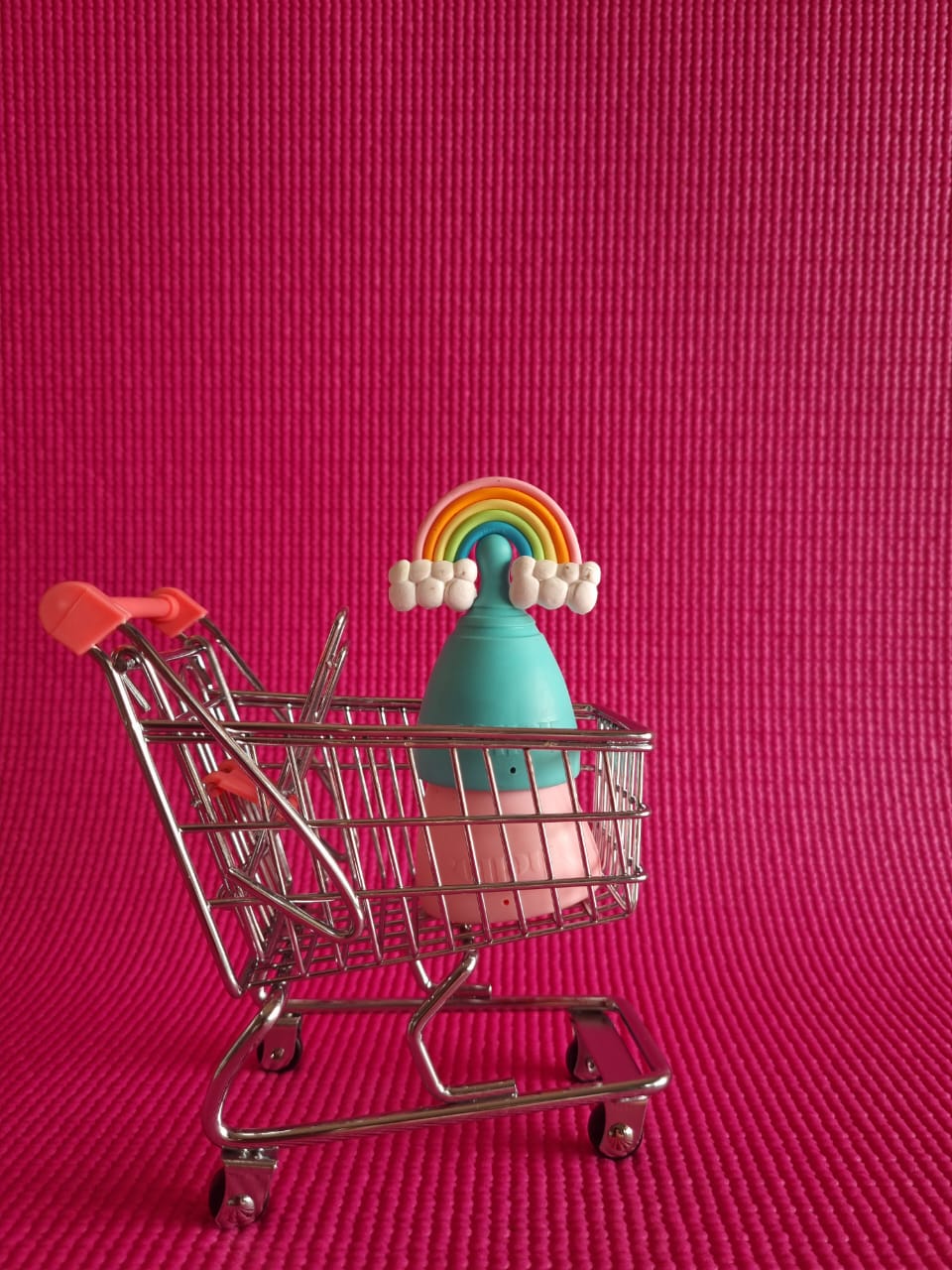 קאפ לווסת בתוך עגלה גביעונית בצבע וורוד וכחול עם קשת ורקע וורוד