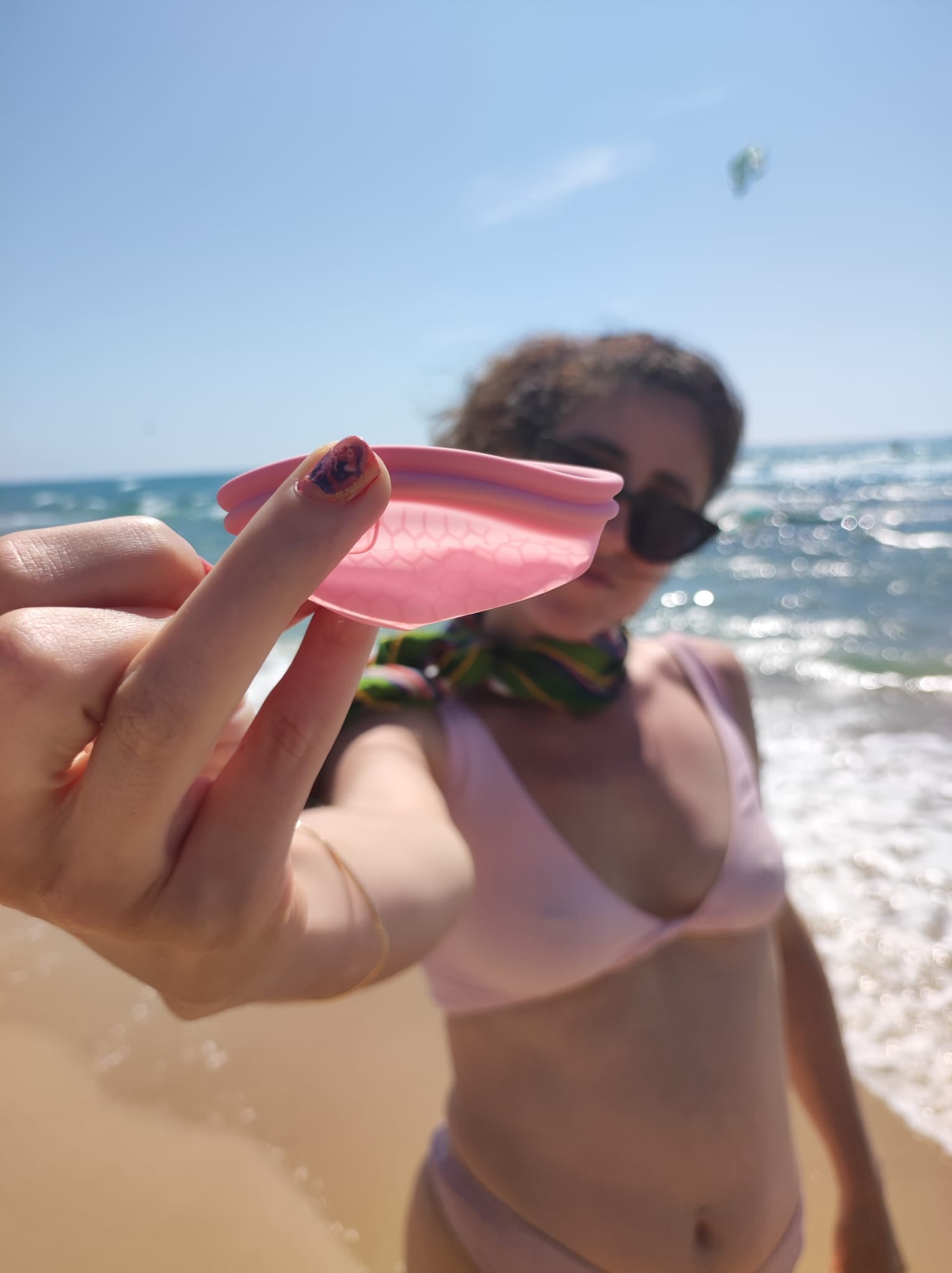women at beach with reusable menstrual cup אישה עם מחזור- דיסק למחזור בים